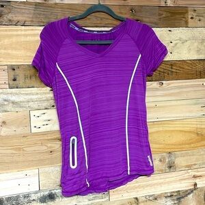 Reebok size small purple short sleeve shirt with reflective strips with pocket
